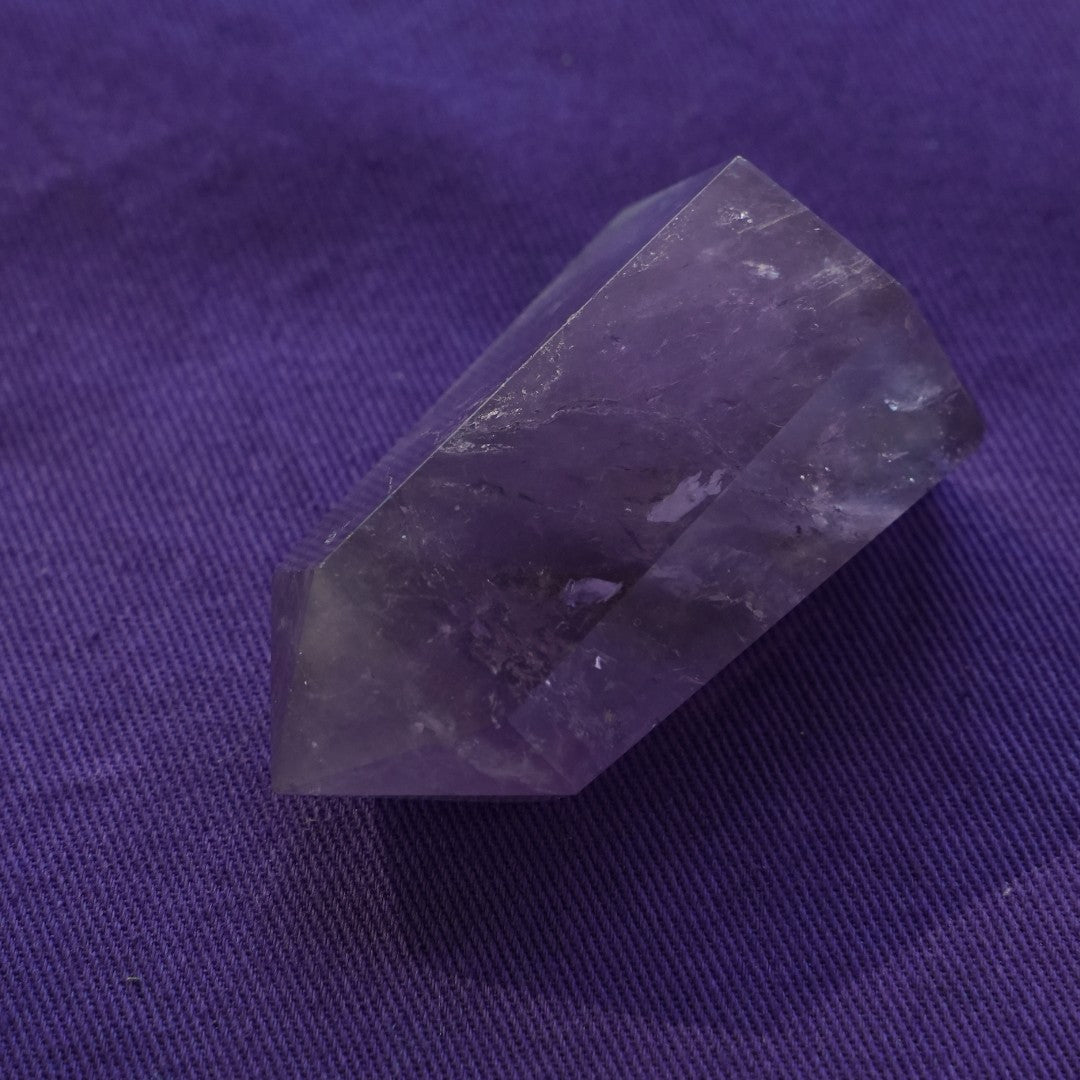 A single amethyst point on purple cloth