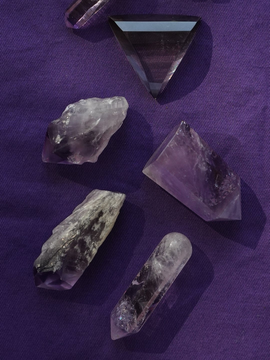 Loose amethyst points on purple cloth