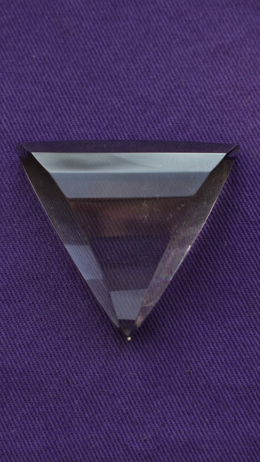 A clear quartz trillion on purple cloth